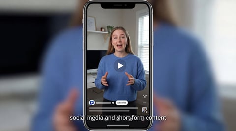 Smartphone screen showing woman recording video content for social media with play icon and text overlay